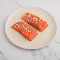 Two salmon filets, meat up with salt sprinkled on top.